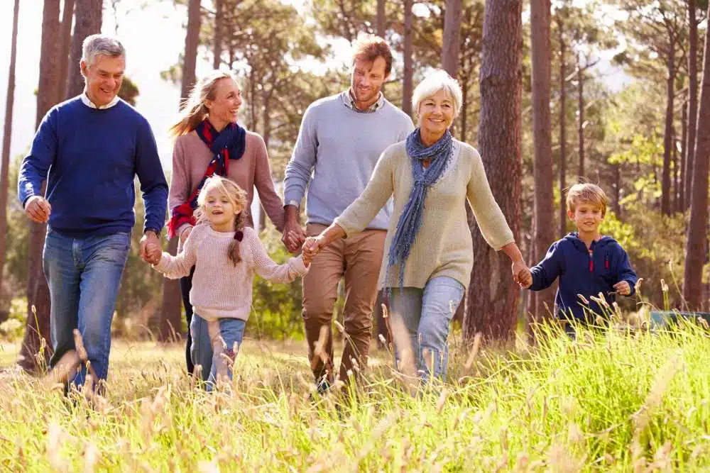 Familia multigeneracional saludable caminando juntos por un campo