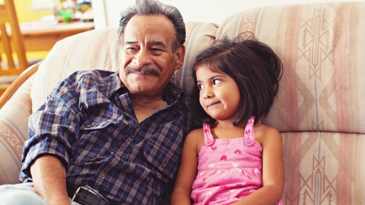 Grandfather and granddaughter sitting on a couch