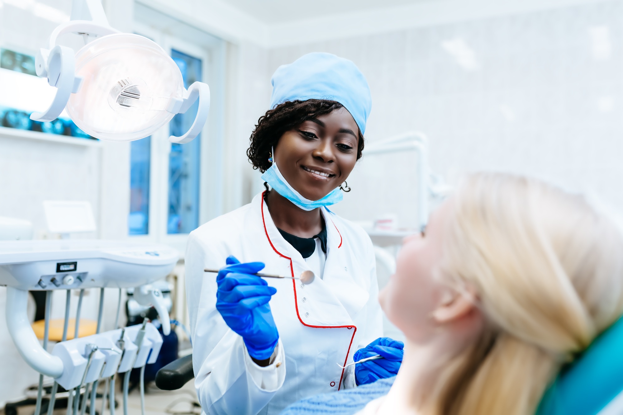 African american female dentist treating patient at clinic. Dental clinic concept