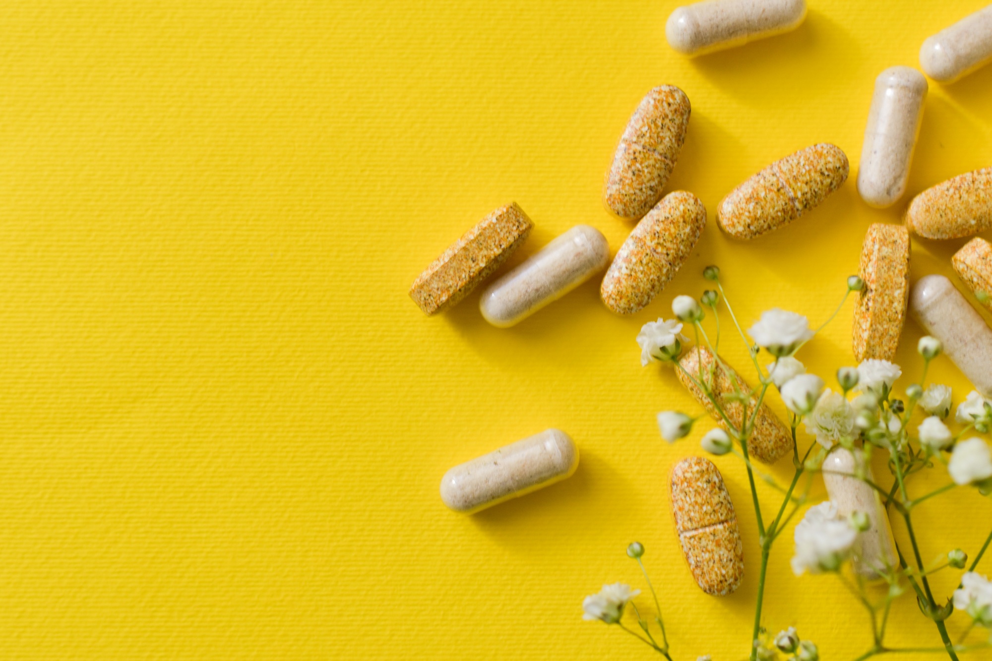 Pills and vitamins on yellow background