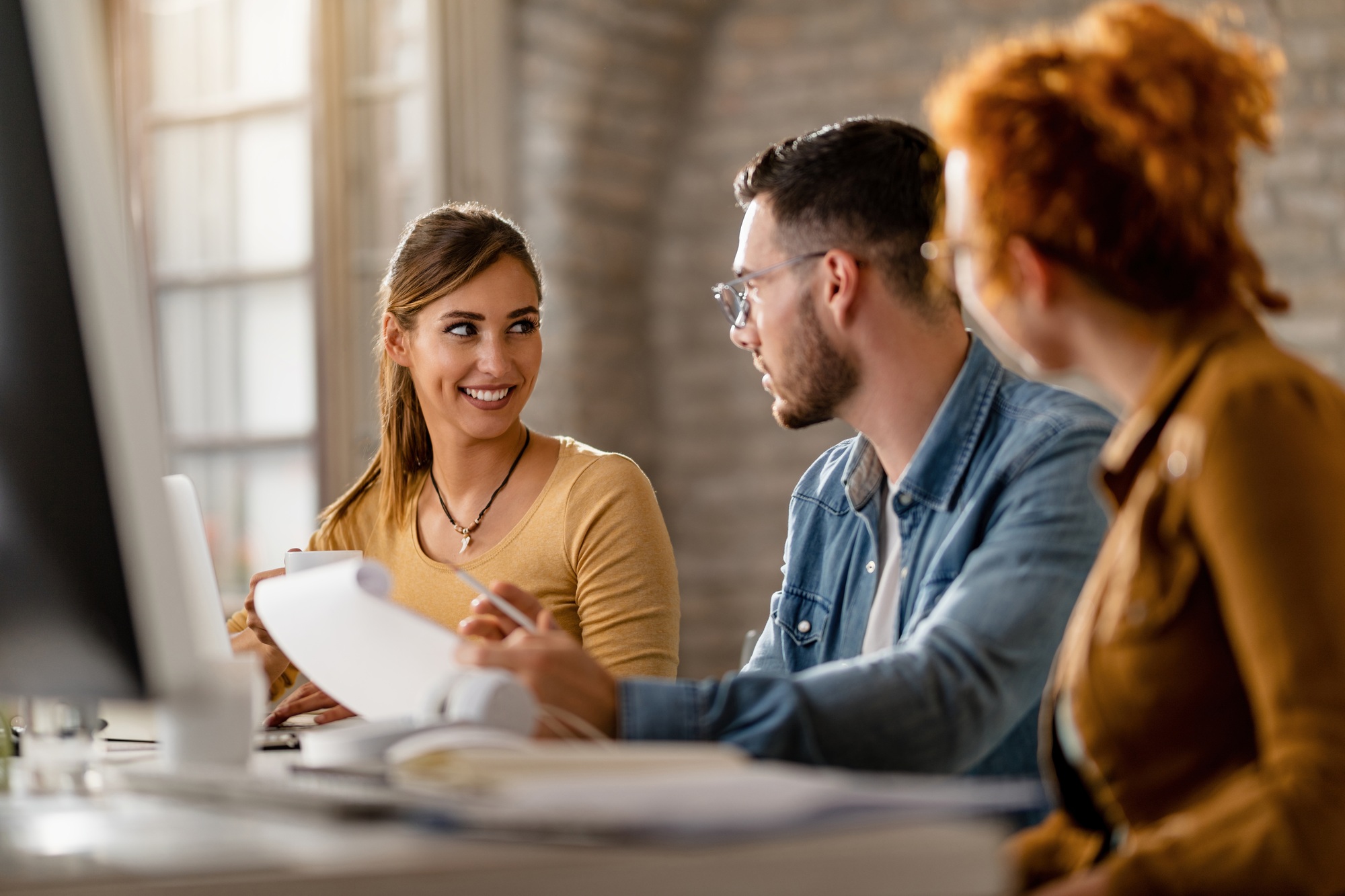 Small group of young entrepreneurs communicating in the office.