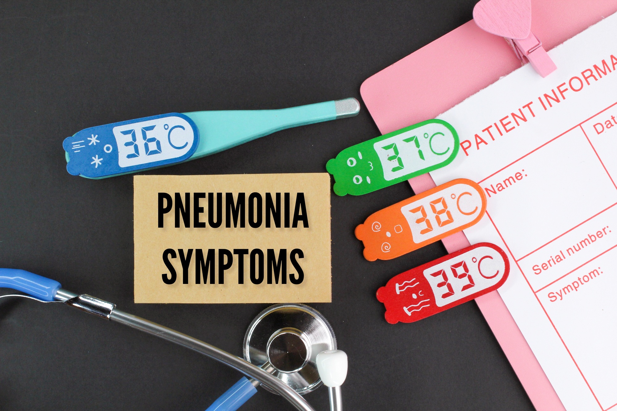 stethoscope and temperature with the word pneumonia symptoms. health and medical concepts