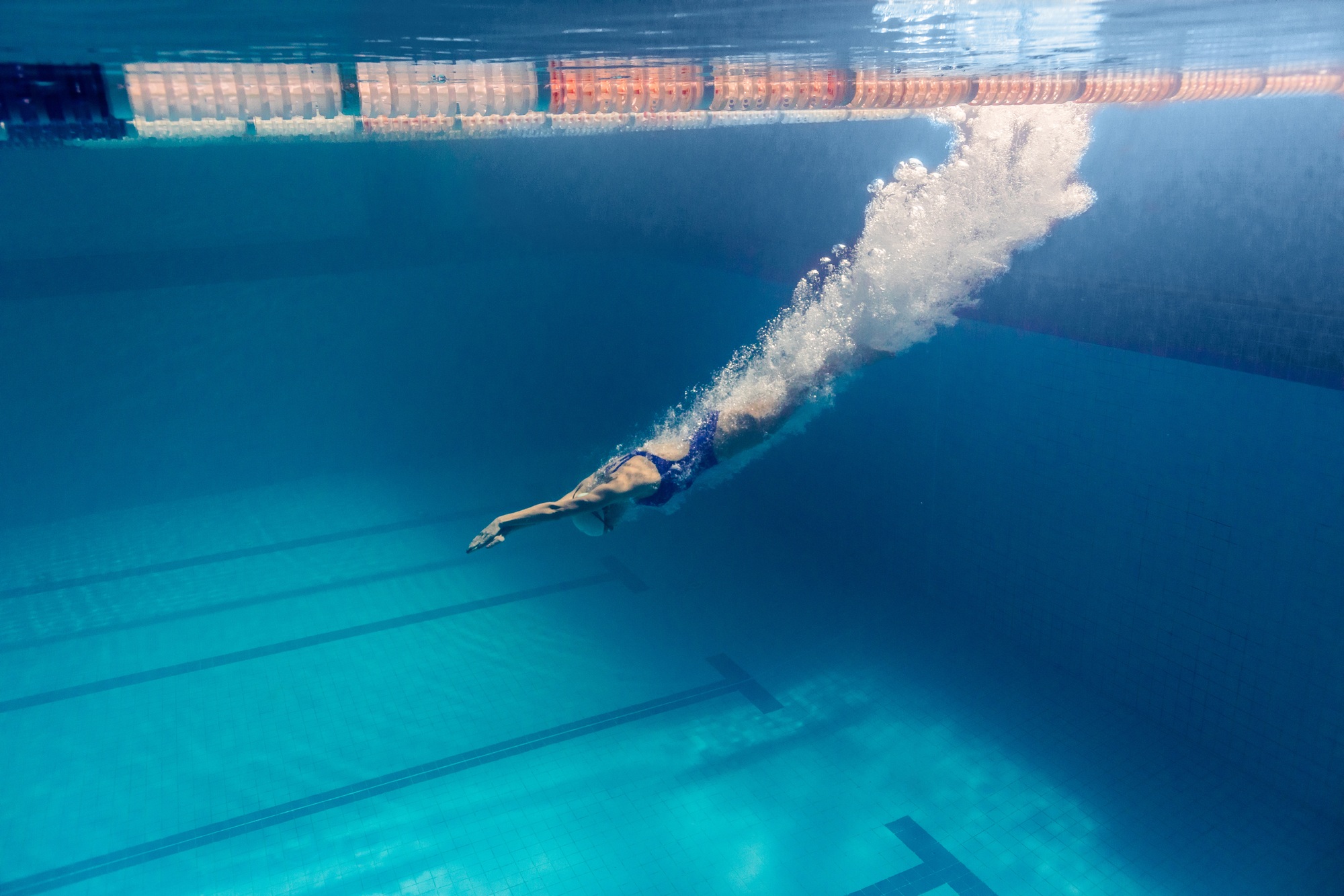 underwater picture of young female swimmer exercising in swimming pool