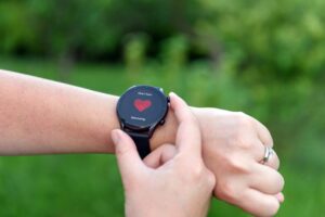 Close-up photo of person monitoring heart rate on smart watch outdoor