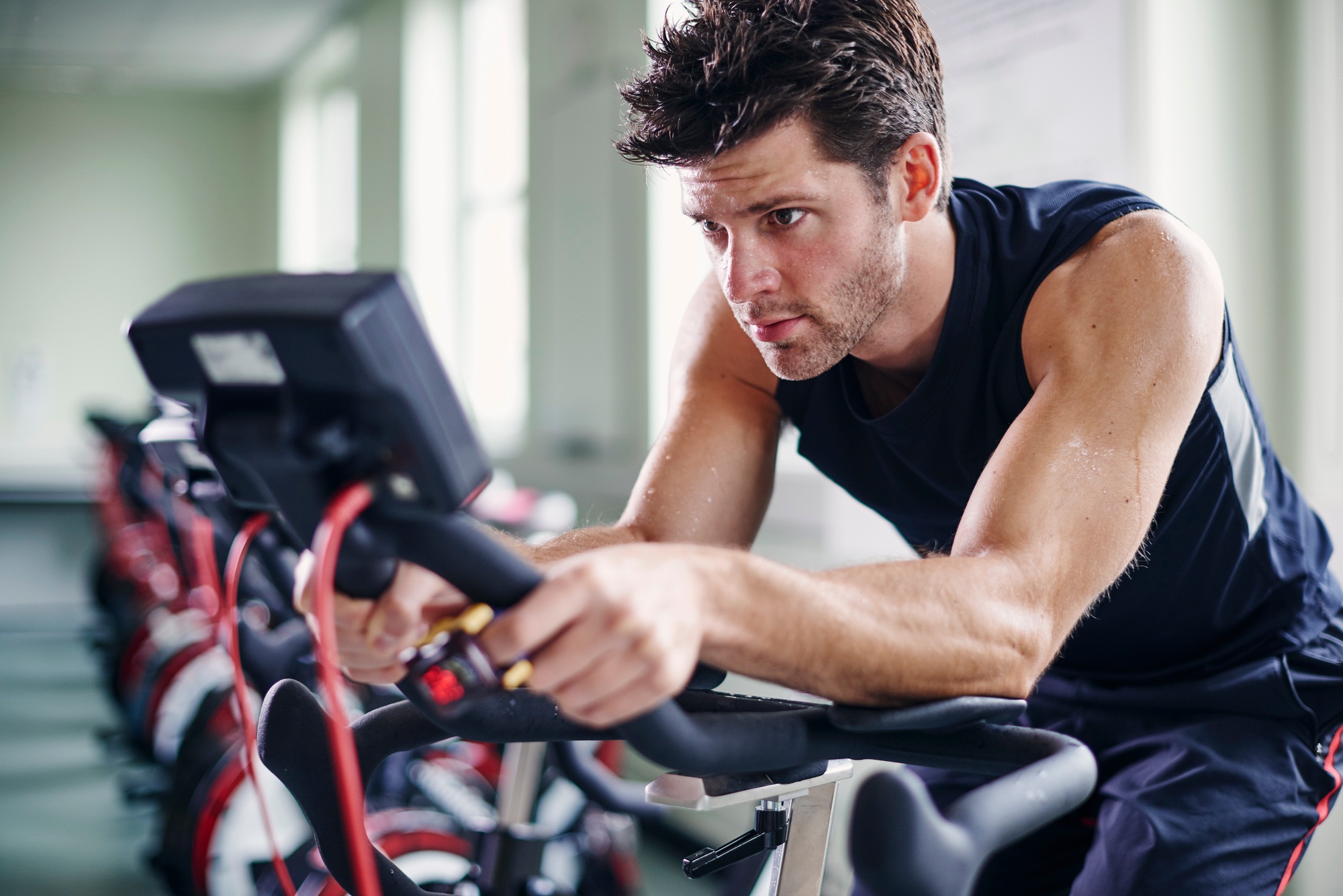 Determined man focusing on his indoor cycling workout