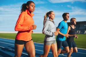 Diverse sports person running on racetrack