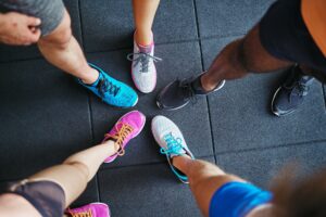 Diverse people wearing running shoes standing in a gym