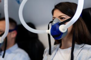 Female patient wearing oxygen mask during hyperbaric oxygen therapy.
