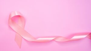 Top view of Pink ribbon on pink background with copy space, Breast cancer symbol, Breast cancer awar