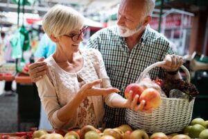 Portrait of beautiful elderly couple in market buing food